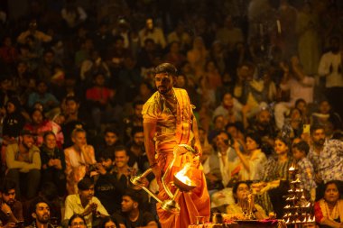 Varanasi, Uttar Pradesh, Hindistan - 21 Mart 2024: Ganga aarti, bir grup genç erkek rahip Assi Ghat 'ta geleneksel Hint ayinleri ile geleneksel elbise giyerek akşam üstü Ganga duası yapıyorlar..