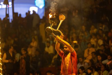 Varanasi, Uttar Pradesh, Hindistan - 21 Mart 2024: Ganga aarti, bir grup genç erkek rahip Assi Ghat 'ta geleneksel Hint ayinleri ile geleneksel elbise giyerek akşam üstü Ganga duası yapıyorlar..