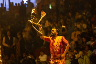 Varanasi, Uttar Pradesh, Hindistan - 21 Mart 2024: Ganga aarti, bir grup genç erkek rahip Assi Ghat 'ta geleneksel Hint ayinleri ile geleneksel elbise giyerek akşam üstü Ganga duası yapıyorlar..