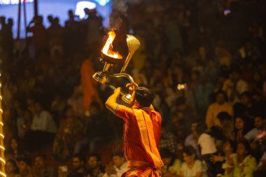 Varanasi, Uttar Pradesh, Hindistan - 21 Mart 2024: Ganga aarti, bir grup genç erkek rahip Assi Ghat 'ta geleneksel Hint ayinleri ile geleneksel elbise giyerek akşam üstü Ganga duası yapıyorlar..