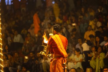 Varanasi, Uttar Pradesh, Hindistan - 21 Mart 2024: Ganga aarti, bir grup genç erkek rahip Assi Ghat 'ta geleneksel Hint ayinleri ile geleneksel elbise giyerek akşam üstü Ganga duası yapıyorlar..