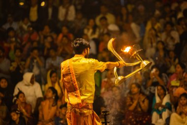 Varanasi, Uttar Pradesh, Hindistan - 21 Mart 2024: Ganga aarti, bir grup genç erkek rahip Assi Ghat 'ta geleneksel Hint ayinleri ile geleneksel elbise giyerek akşam üstü Ganga duası yapıyorlar..