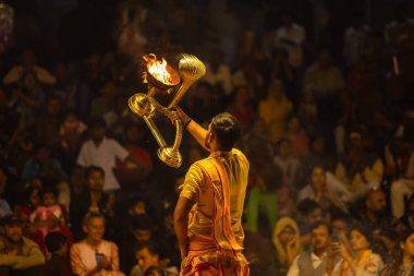 Varanasi, Uttar Pradesh, Hindistan - 21 Mart 2024: Ganga aarti, bir grup genç erkek rahip Assi Ghat 'ta geleneksel Hint ayinleri ile geleneksel elbise giyerek akşam üstü Ganga duası yapıyorlar..
