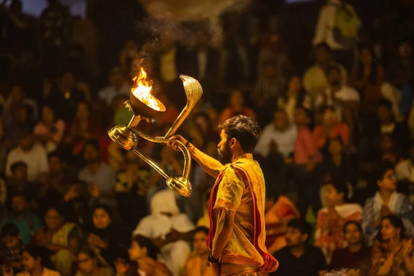 Varanasi, Uttar Pradesh, Hindistan - 21 Mart 2024: Ganga aarti, bir grup genç erkek rahip Assi Ghat 'ta geleneksel Hint ayinleri ile geleneksel elbise giyerek akşam üstü Ganga duası yapıyorlar..