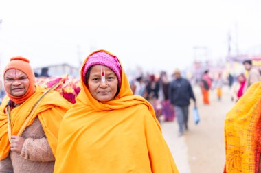 Prayagraj, Uttar Pradesh, Hindistan - 15 Ocak 2025: Mahakumbh, erkek ve dişi sadhu grubu, kış sabahı ibadet etmek ve ayinleri gerçekleştirmek için.