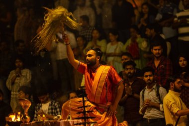 Varanasi, Uttar Pradesh, Hindistan - 21 Mart 2024: Ganga aarti, bir grup genç erkek rahip Assi Ghat 'ta geleneksel Hint ayinleri ile geleneksel elbise giyerek akşam üstü Ganga duası yapıyorlar..