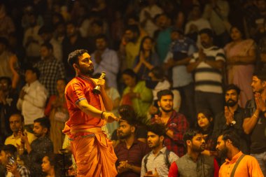 Varanasi, Uttar Pradesh, Hindistan - 21 Mart 2024: Ganga aarti, bir grup genç erkek rahip Assi Ghat 'ta geleneksel Hint ayinleri ile geleneksel elbise giyerek akşam üstü Ganga duası yapıyorlar..