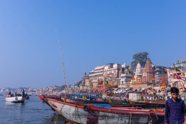 Varanasi, Uttar Pradesh, Hindistan - 22 Mart 2024: Varanasi 'deki nehir çetelerinin yakınlarındaki ghatların mimari görüşü. Ganga nehrinde yüzen tekneden binaların görüntüsü.