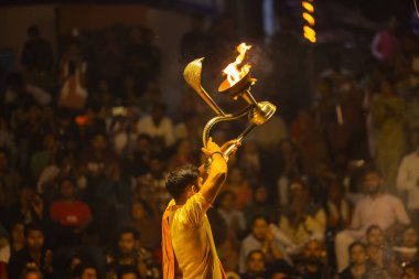 Varanasi, Uttar Pradesh, Hindistan - 21 Mart 2024: Ganga aarti, bir grup genç erkek rahip Assi Ghat 'ta geleneksel Hint ayinleri ile geleneksel elbise giyerek akşam üstü Ganga duası yapıyorlar..