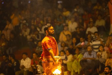 Varanasi, Uttar Pradesh, Hindistan - 21 Mart 2024: Ganga aarti, bir grup genç erkek rahip Assi Ghat 'ta geleneksel Hint ayinleri ile geleneksel elbise giyerek akşam üstü Ganga duası yapıyorlar..