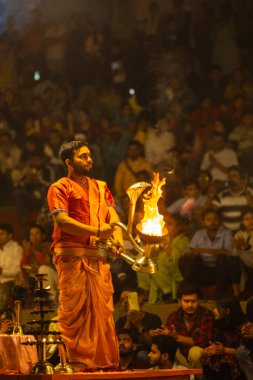 Varanasi, Uttar Pradesh, Hindistan - 21 Mart 2024: Ganga aarti, bir grup genç erkek rahip Assi Ghat 'ta geleneksel Hint ayinleri ile geleneksel elbise giyerek akşam üstü Ganga duası yapıyorlar..