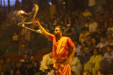 Varanasi, Uttar Pradesh, Hindistan - 21 Mart 2024: Ganga aarti, bir grup genç erkek rahip Assi Ghat 'ta geleneksel Hint ayinleri ile geleneksel elbise giyerek akşam üstü Ganga duası yapıyorlar..