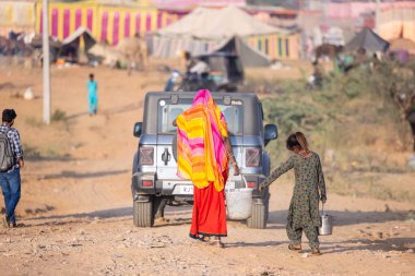 Puşkar, Rajasthan, Hindistan - 10 Kasım 2024: Pushkar Deve Fuarı 'nda kimliği belirsiz Hintli Rajasthani kadınlarının portresi.