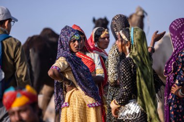 Puşkar, Rajasthan, Hindistan - 11 Kasım 2024: Kimliği belirsiz Hintli Rajasthani kadınlarından oluşan bir grup kış sabahı Pushkar Camel Panayırı 'nda dans ediyor.