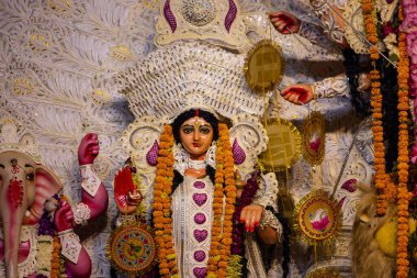 Navratri için dekore edilmiş güzel el yapımı renkli bir tanrıça Durga idolü, renkli pandallarda canlı geleneksel kıyafetler, karmaşık mücevherler ve ilahi ifadeler içeriyor..