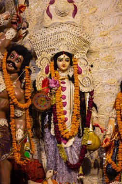 Navratri için dekore edilmiş güzel el yapımı renkli bir tanrıça Durga idolü, renkli pandallarda canlı geleneksel kıyafetler, karmaşık mücevherler ve ilahi ifadeler içeriyor..