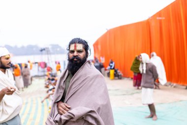 Prayagraj, Uttar Pradesh, Hindistan - 15 Ocak 2025: Mahakumbh, bir grup kutsal erkek sadhu namaz kılmak ve kış sabahı ayinlerini gerçekleştirmek için.