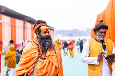 Prayagraj, Uttar Pradesh, Hindistan - 15 Ocak 2025: Mahakumbh, bir grup kutsal erkek sadhu namaz kılmak ve kış sabahı ayinlerini gerçekleştirmek için.