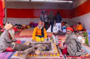 Prayagraj, Uttar Pradesh, Hindistan - 15 Ocak 2025: Mahakumbh, bir grup kutsal erkek sadhu namaz kılmak ve kış sabahı ayinlerini gerçekleştirmek için.