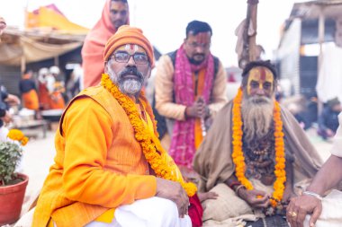 Prayagraj, Uttar Pradesh, Hindistan - 15 Ocak 2025: Mahakumbh, bir grup kutsal erkek sadhu namaz kılmak ve kış sabahı ayinlerini gerçekleştirmek için.