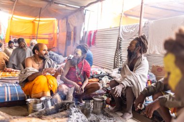 Prayagraj, Uttar Pradesh, Hindistan - 15 Ocak 2025: Mahakumbh, bir grup kutsal erkek sadhu namaz kılmak ve kış sabahı ayinlerini gerçekleştirmek için.