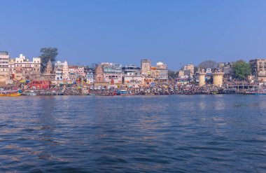 Varanasi, Uttar Pradesh, Hindistan - 22 Mart 2024: Varanasi 'deki nehir çetelerinin yakınındaki ghatların mimari görüşü ve tapınakları. Ganga nehrinde yüzen tekneden binaların görüntüsü.