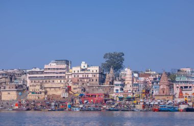 Varanasi, Uttar Pradesh, Hindistan - 22 Mart 2024: Varanasi 'deki nehir çetelerinin yakınındaki ghatların mimari görüşü ve tapınakları. Ganga nehrinde yüzen tekneden binaların görüntüsü.