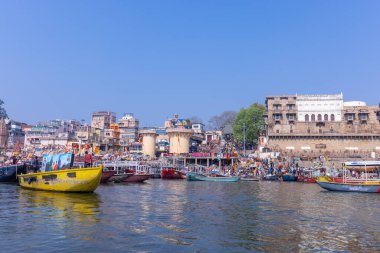 Varanasi, Uttar Pradesh, Hindistan - 22 Mart 2024: Varanasi 'deki nehir çetelerinin yakınındaki ghatların mimari görüşü ve tapınakları. Ganga nehrinde yüzen tekneden binaların görüntüsü.
