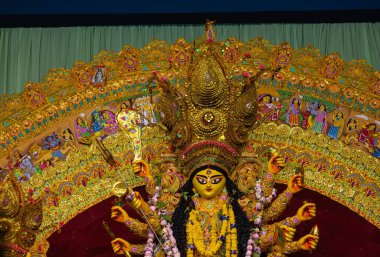 Navratri için dekore edilmiş güzel el yapımı renkli bir tanrıça Durga idolü. Renkli pandallarda canlı geleneksel kıyafetler, karmaşık mücevherler ve ilahi ifadeler içeriyor..