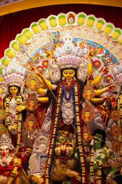 Navratri için dekore edilmiş güzel el yapımı renkli bir tanrıça Durga idolü. Renkli pandallarda canlı geleneksel kıyafetler, karmaşık mücevherler ve ilahi ifadeler içeriyor..
