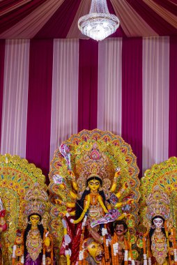Navratri için dekore edilmiş güzel el yapımı renkli bir tanrıça Durga idolü. Renkli pandallarda canlı geleneksel kıyafetler, karmaşık mücevherler ve ilahi ifadeler içeriyor..
