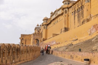 Jaipur 'daki kehribar kalesinde madalyalı file binen kimliği belirsiz bir turist. Arkaplanda Amber Kalesi 'nin mimari görünümü.
