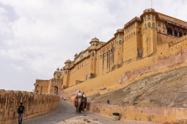 Jaipur 'daki kehribar kalesinde madalyalı file binen kimliği belirsiz bir turist. Arkaplanda Amber Kalesi 'nin mimari görünümü.