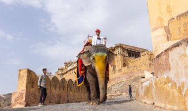 Jaipur 'daki kehribar kalesinde madalyalı file binen kimliği belirsiz bir turist. Arkaplanda Amber Kalesi 'nin mimari görünümü.