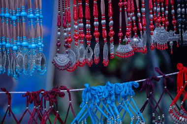 Etnik kolye ve diğer mücevherler arka planda bulanık bir şekilde satışta..