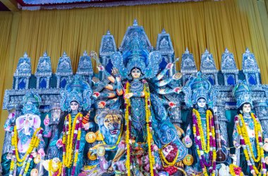 Navratri için dekore edilmiş güzel el yapımı renkli bir tanrıça Durga idolü. Renkli pandallarda canlı geleneksel kıyafetler, karmaşık mücevherler ve ilahi ifadeler içeriyor..