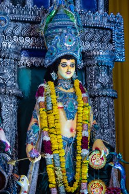 Navratri için dekore edilmiş güzel el yapımı renkli bir tanrıça Durga idolü, renkli pandallarda canlı geleneksel kıyafetler, karmaşık mücevherler ve ilahi ifadeler içeriyor..