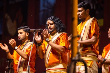 Varanasi, Uttar Pradesh, Hindistan - 21 Mart 2024: Ganga aarti, bir grup genç erkek rahip Assi Ghat 'ta geleneksel Hint ayinleri ile geleneksel elbise giyerek akşam üstü Ganga duası yapıyorlar..