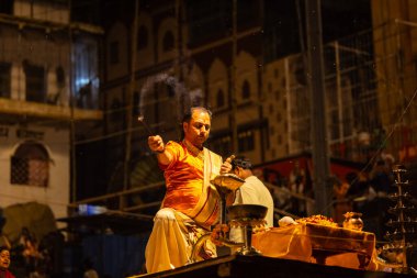 Varanasi, Uttar Pradesh, Hindistan - 21 Mart 2024: Ganga aarti, bir grup genç erkek rahip Assi Ghat 'ta geleneksel Hint ayinleri ile geleneksel elbise giyerek akşam üstü Ganga duası yapıyorlar..