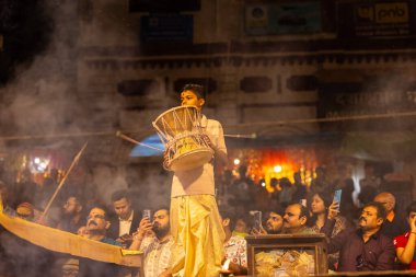 Varanasi, Uttar Pradesh, Hindistan - 21 Mart 2024: Ganga aarti, bir grup genç erkek rahip Assi Ghat 'ta geleneksel Hint ayinleri ile geleneksel elbise giyerek akşam üstü Ganga duası yapıyorlar..