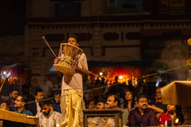 Varanasi, Uttar Pradesh, Hindistan - 21 Mart 2024: Ganga aarti, bir grup genç erkek rahip Assi Ghat 'ta geleneksel Hint ayinleri ile geleneksel elbise giyerek akşam üstü Ganga duası yapıyorlar..