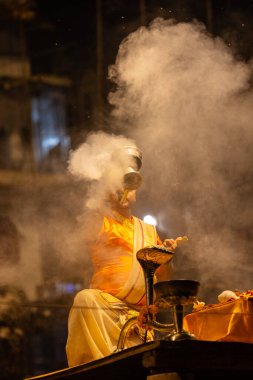 Varanasi, Uttar Pradesh, Hindistan - 21 Mart 2024: Ganga aarti, bir grup genç erkek rahip Assi Ghat 'ta geleneksel Hint ayinleri ile geleneksel elbise giyerek akşam üstü Ganga duası yapıyorlar..