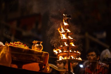 Varanasi, Uttar Pradesh, Hindistan - 21 Mart 2024: Ganga aarti, bir grup genç erkek rahip Assi Ghat 'ta geleneksel Hint ayinleri ile geleneksel elbise giyerek akşam üstü Ganga duası yapıyorlar..
