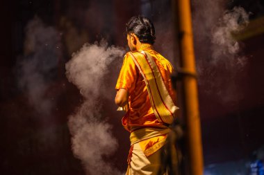 Varanasi, Uttar Pradesh, Hindistan - 21 Mart 2024: Ganga aarti, bir grup genç erkek rahip Assi Ghat 'ta geleneksel Hint ayinleri ile geleneksel elbise giyerek akşam üstü Ganga duası yapıyorlar..