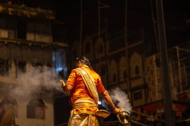 Varanasi, Uttar Pradesh, Hindistan - 21 Mart 2024: Ganga aarti, bir grup genç erkek rahip Assi Ghat 'ta geleneksel Hint ayinleri ile geleneksel elbise giyerek akşam üstü Ganga duası yapıyorlar..
