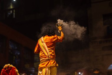 Varanasi, Uttar Pradesh, Hindistan - 21 Mart 2024: Ganga aarti, bir grup genç erkek rahip Assi Ghat 'ta geleneksel Hint ayinleri ile geleneksel elbise giyerek akşam üstü Ganga duası yapıyorlar..