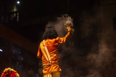 Varanasi, Uttar Pradesh, Hindistan - 21 Mart 2024: Ganga aarti, bir grup genç erkek rahip Assi Ghat 'ta geleneksel Hint ayinleri ile geleneksel elbise giyerek akşam üstü Ganga duası yapıyorlar..