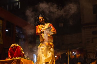 Varanasi, Uttar Pradesh, Hindistan - 21 Mart 2024: Ganga aarti, bir grup genç erkek rahip Assi Ghat 'ta geleneksel Hint ayinleri ile geleneksel elbise giyerek akşam üstü Ganga duası yapıyorlar..