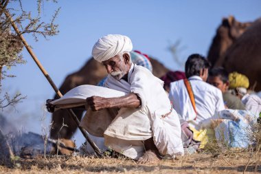 Puşkar, Rajasthan, Hindistan - 11 Kasım 2024: Geleneksel beyaz giysili rajasthani erkek portresi.