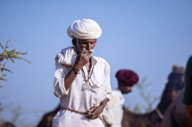 Puşkar, Rajasthan, Hindistan - 11 Kasım 2024: Geleneksel beyaz giysili rajasthani erkek portresi.